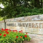 Cornell Promises DEEP Review After Assault Claims Cornell University stone entrance sign with red flowers
