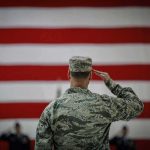 Why Invading America Would Be a NIGHTMARE Soldier saluting before a large American flag