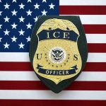 DOJ Sues Over Law Unmasking Federal Agents ICE officer badge on American flag background