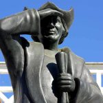 See What Trump Said About Christopher Columbus That Has Dems FUMING Bronze statue of a historical figure saluting against a blue sky