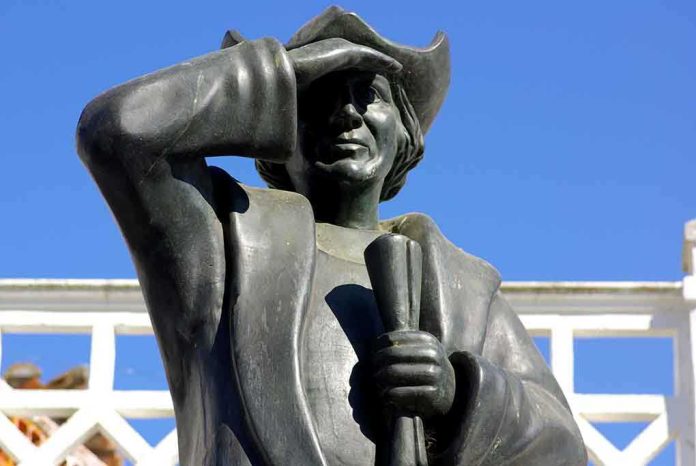 shutterstock_4714579 Bronze statue of a historical figure saluting against a blue sky