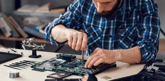 Palantir CEO Warns Who Will SURVIVE the AI Era Technician repairing a laptop motherboard at a workbench
